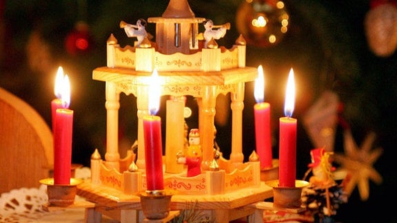 Brennende Kerzen auf einer Weihnachtspyramide.