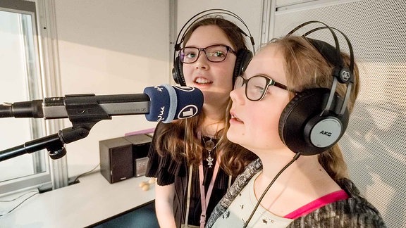 Zwei Mädchen singen in der MDR-Clara-Klangbox auf der Buchmesse in Mikrofone.