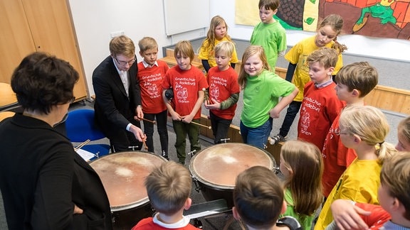 Mitmachkonzert in Radeburg: Grundschulkinder umringen einen Musiker.