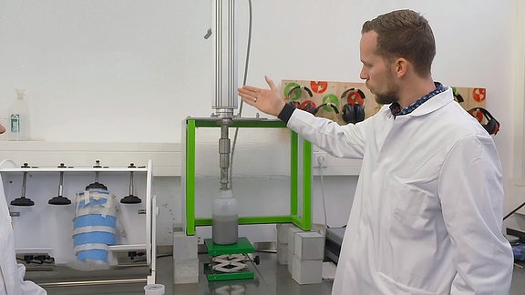 Ein Mann demonstriert das Ultraschall-Gerät unter Laborbedingungen