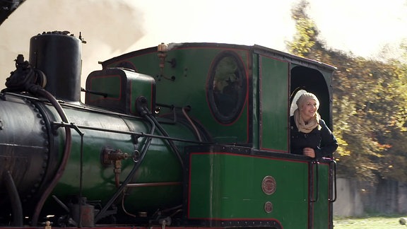 Henriette Fee-Grützner schaut aus dem Fenster eine fahrenden Lokomotive.