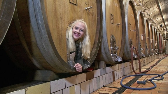 Henriette schaut aus einem Weinfass