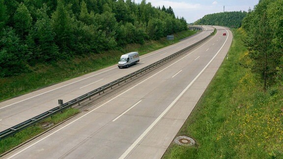  Ein weißer Kleintransporter fährt auf einer Autobahn.  