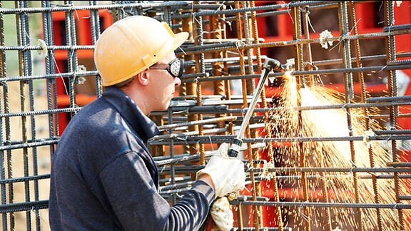 Ein Arbeiter schweißt auf einer Baustelle.