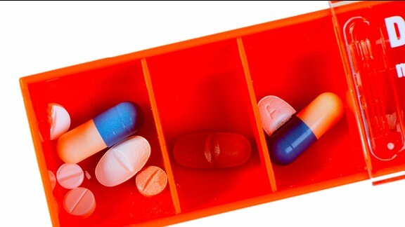 Verschiedene Tabletten in den Fächern einer Tablettenbox.