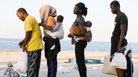 EU will Asylreform: Menschen aus Afrika warten auf der italienischen Insel Lampedusa auf ein Schiff zum italienischen Festland.