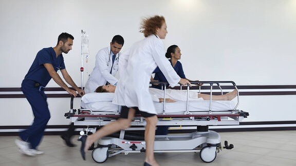 Krankenhauspersonal bringt einen Patienten zur Notfallversorgung.