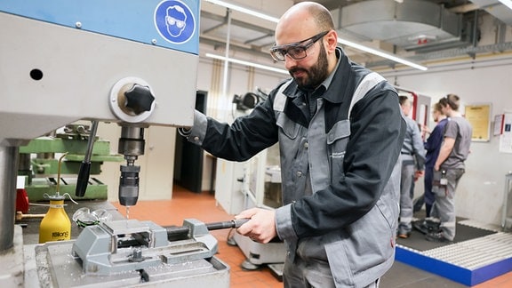 Mohamad Hakam Almashhrawi aus Syrien, Auszubildender bei den Stadtwerken Flensburg, arbeitet in der Ausbildungswerkstatt bei einem Besuch von Schleswig-Holsteins Arbeitsstaatssekretär von der Heide. 