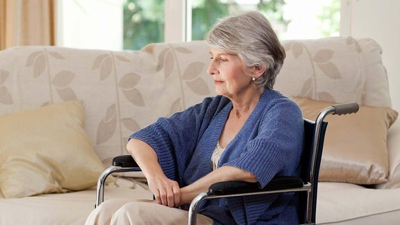 Eine Seniorin sitzt in einem Rollstuhl