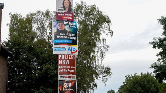Verschiedene Wahlplakate an einer Straßenlaterne