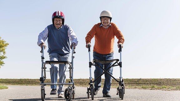 Zwei Senioren mit Helm und Rollator