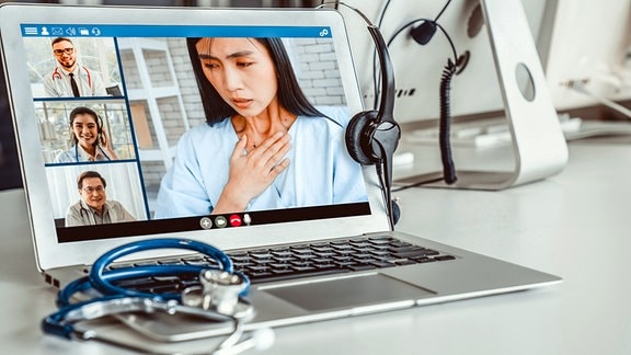 Symbolbild Telemedizin - Junge Frau mit Halsbeschwerden im Videochat mit Ärzten