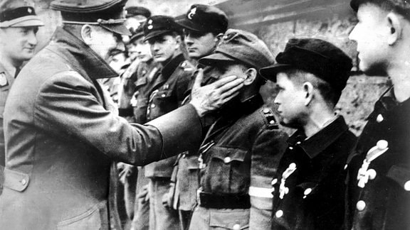 Adolf Hitler  bei der Auszeichnung von Mitgliedern der Berliner Hitler-Jugend, die zum Ende des Zweiten Weltkrieges in Volkssturmeinheiten zusammengefaßt wurden.
