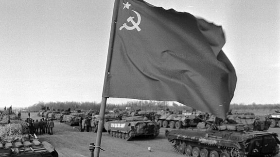 Landesfahne der UDSSR und parkende Panzer im Zwischenlager des usbekischen Termez - Abzug der Sowjetischen Truppen aus Afghanistan.