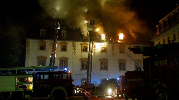 Löschfahrzeuge der Feuerwehr im Nachteinsatz - Flammen schlagen durchs Fenster während des Brandes der Anna Amalia Bibliothek in Weimar.
