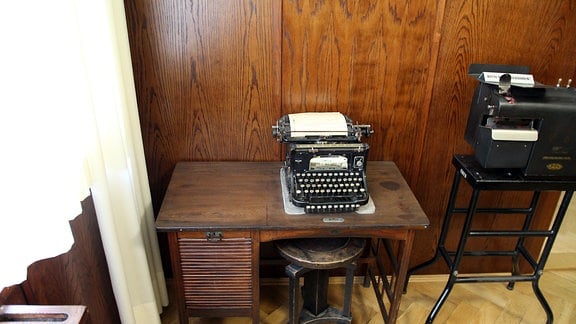 Alte Schreibmaschine auf historischem Schreibtisch mit Rollladentür