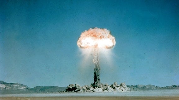 Ein Atompilz steigt nach der Explosion einer Atombombe über dem Testgelände in der Wüste von Nevada auf
