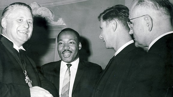 Martin Luther King in der Marienkirche, umgeben von drei Männern