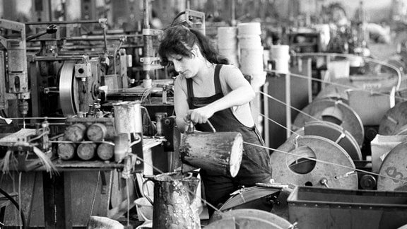 Eine Arbeiterin mit einer Kanne Schmiermittel 1987 an einer Anlage in der Wickeldrahtfabrik des KWO Berlin