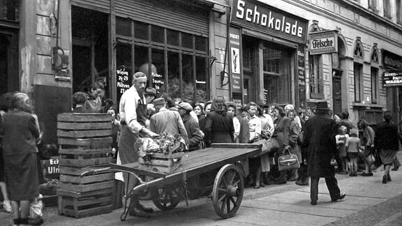 Menschen warten 1948 vor einem Geschäft