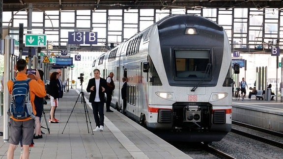 Menschen posieren vor einem Intercity-Zug im Chemnitzer Hauptbahnhof