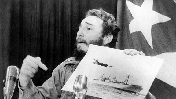Präsident Fidel Castro (CUB) deutet während eines Fernsehauftritts in Havanna auf ein Foto mit einem US-Aufklärungsflugzeug und dem Sowjetischen Frachter.