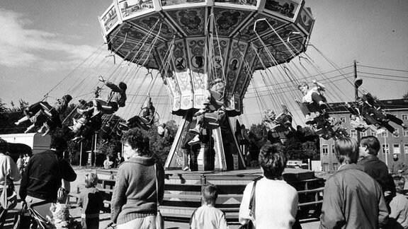 Menschen an einem Kettenkarusell, 1988 in Karl-Marx-Stadt