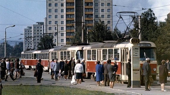 Tatra Straßenbahn an der Haltestelle Postplatz und Neubaublock mit sozialistischem Slogan in Dresden, 1970.