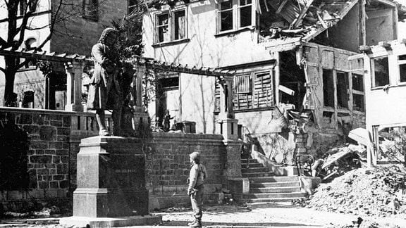 Ein US-Soldat steht im April 1945 in Eisenach vor der Statue des deutschen Komponisten Johann Sebastian Bach.