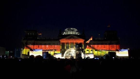 Lichtinstallation an der Fassade vom Reichstag in den Farben Schwarz-Rot-Gold beim Fest zum 20. Jahrestag der Deutschen Einheit vor dem Reichstag in Berlin.