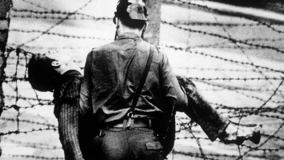 Ein Grenzsoldat trägt einen Mann (Peter Fechter)