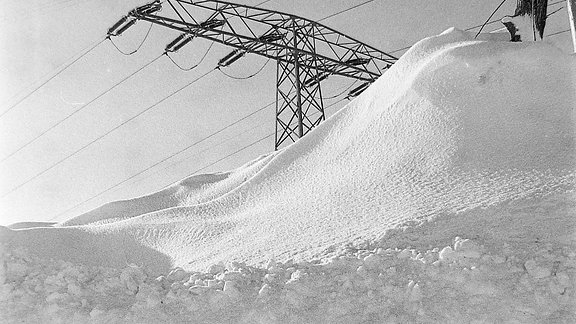 Hohe Schneewehe vor einem Strommast