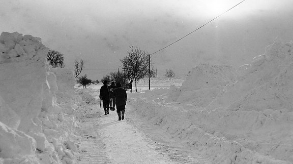 Menschen laufen durch Schnee.