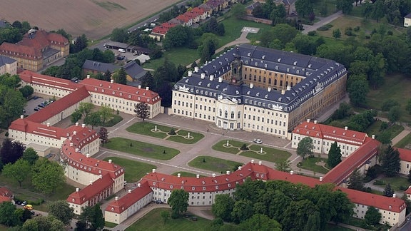 Luftaufnahme des Schloss Hubertusburg in Wermsdorf, ein großer Gebäudekomplex mit Park.