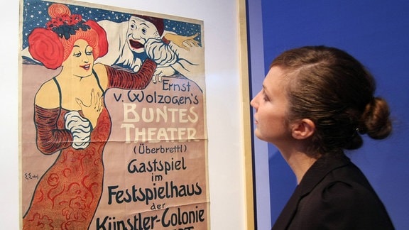 Eine Besucherin betrachtet am Freitag (05.10.2012) in der Ausstellung Alles Reklame! Die Plakatkunst der Künstlerkolonie Darmstadt das Plakat Ernst von Wolzogen s Buntes Theater von Edmund Edel aus dem Jahr 1901
