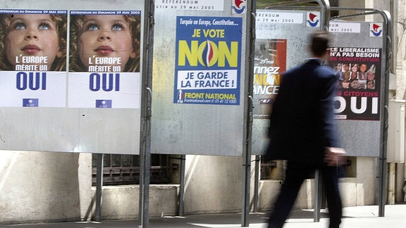 Passant läuft in Paris an Plakaten verschiedener Parteien zum EU-Referendum vorbei