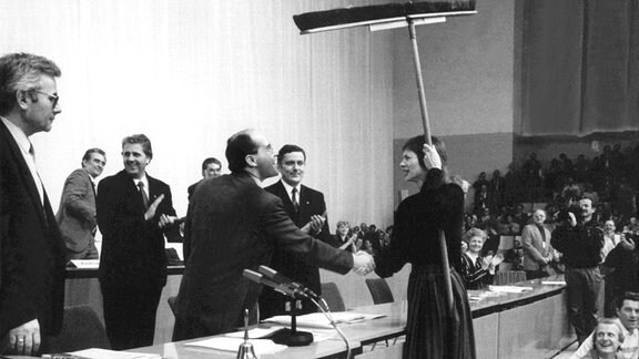 Der neugewählte Vorsitzende der SED, Dr. Gregor Gysi (M), wird nach seiner Wahl beim außerordentlichen Parteitag am 10. Dezember 1989 in Ostberlin unter dem Beifall der Delegierten mit einem symbolischen Geschenk zum großen "Saubermacher" gekürt. 