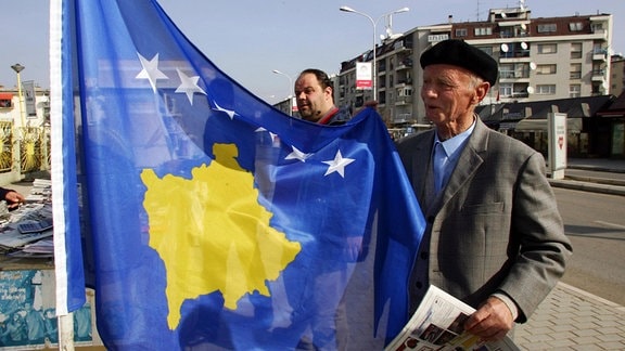 Älterer Kosovare mit einer Flagge der selbsternannten Republik Kosovo in Pristina.