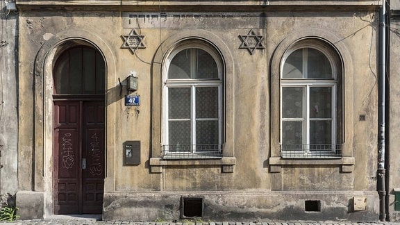 Überreste von Torah-Aufschrift und Davidsterne auf Hausfassade in Kazimierz