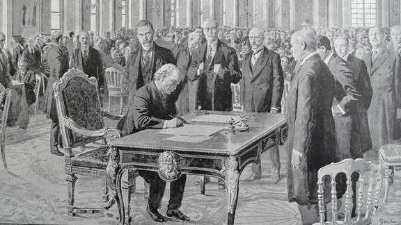 Der Britische Premierminister David Lloyd George unterzeichnet den Versailler Vertrag am 28. Juni 1919.