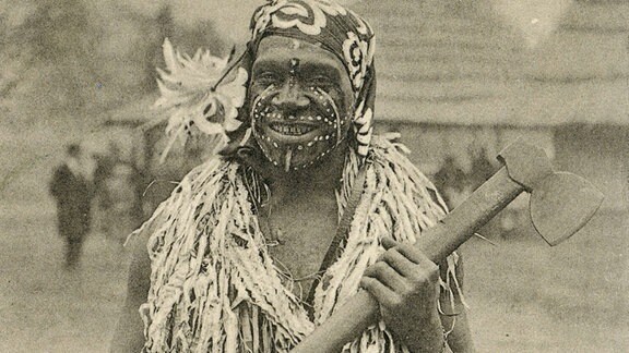 MAnn auf einer Posrkarte mit der Aufschrift "Aus der Völkerschau der Kannibalen von den Südsee-Inseln"