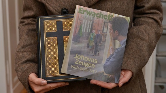 Zeuge Jehovas mit Bibel und Broschüre Erwachet.