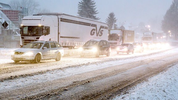 Mehrere Autos und Lkw fahren auf der mehrspurigen B174 nebeneinander durch dichtes Schneetreiben.