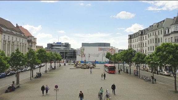 Marktplatz in Halle/Saale. Links und rechts: Häuserzeilen und Bäume. Im Hintergrund: Hörfunkzentrale des MDR.