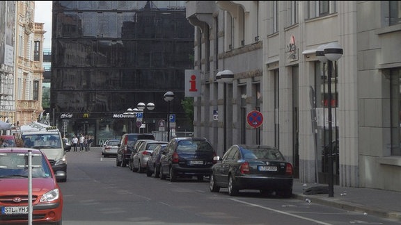 Blick in die Katharinenstraße Richtung Brühl, rechts zeigt ein Schild mit einem rotem „i“ das neue Domizil der Stadtinformation an, das schwarze Gebäude gehört zum neuen großen Einkaufszentrum „Höfe am Brühl“, dahinter ist ein Stück vom Hotel „Westin“ zu sehen, Aufnahme Juni 2014