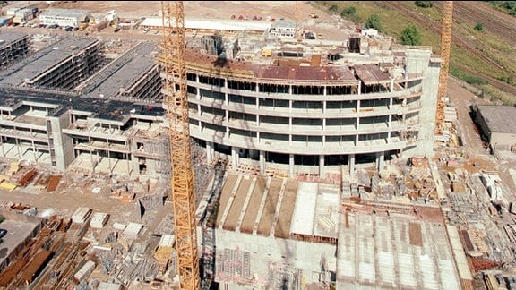 Blick von oben im August 1998 auf das Baugeschehen der MDR-Zentrale in Leipzig. Drei Kräne errichten das einem Fernsehbildschirm nachempfundene Hochhaus. Es wird 13 Etagen haben.