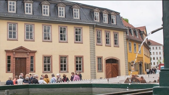 Goethehaus in Weimar. Gelb gestrichenes zweistöckiges Gebäude mit Sprossenfenstern, davor eine Touristengruppe.