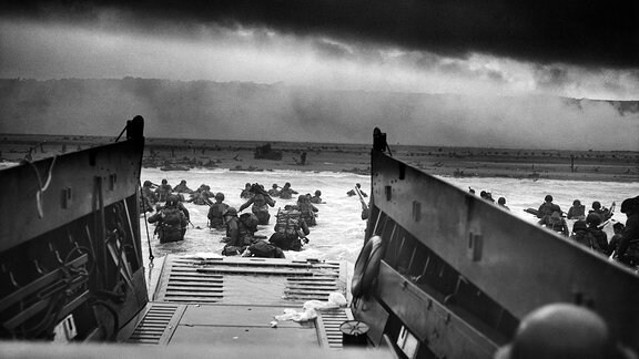 US-Truppen waten durch Wasser, nachdem sie die Normandie erreicht haben und am D-Day am Omaha Beach landen