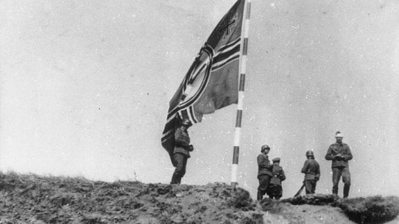 Deutsche Soldaten und Kriegsflagge nach Eroberung der Westerplatte