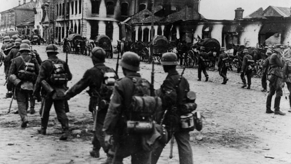 Deutsche Soldaten marschieren 1941 durch eine sowjetische Stadt